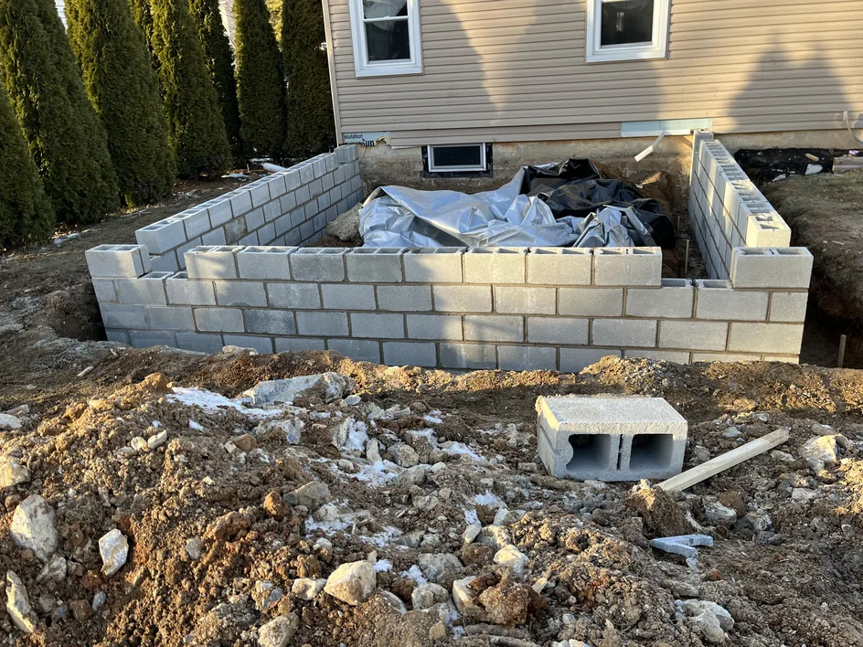 New concrete block foundation walls for a home addition beside a house, block walls