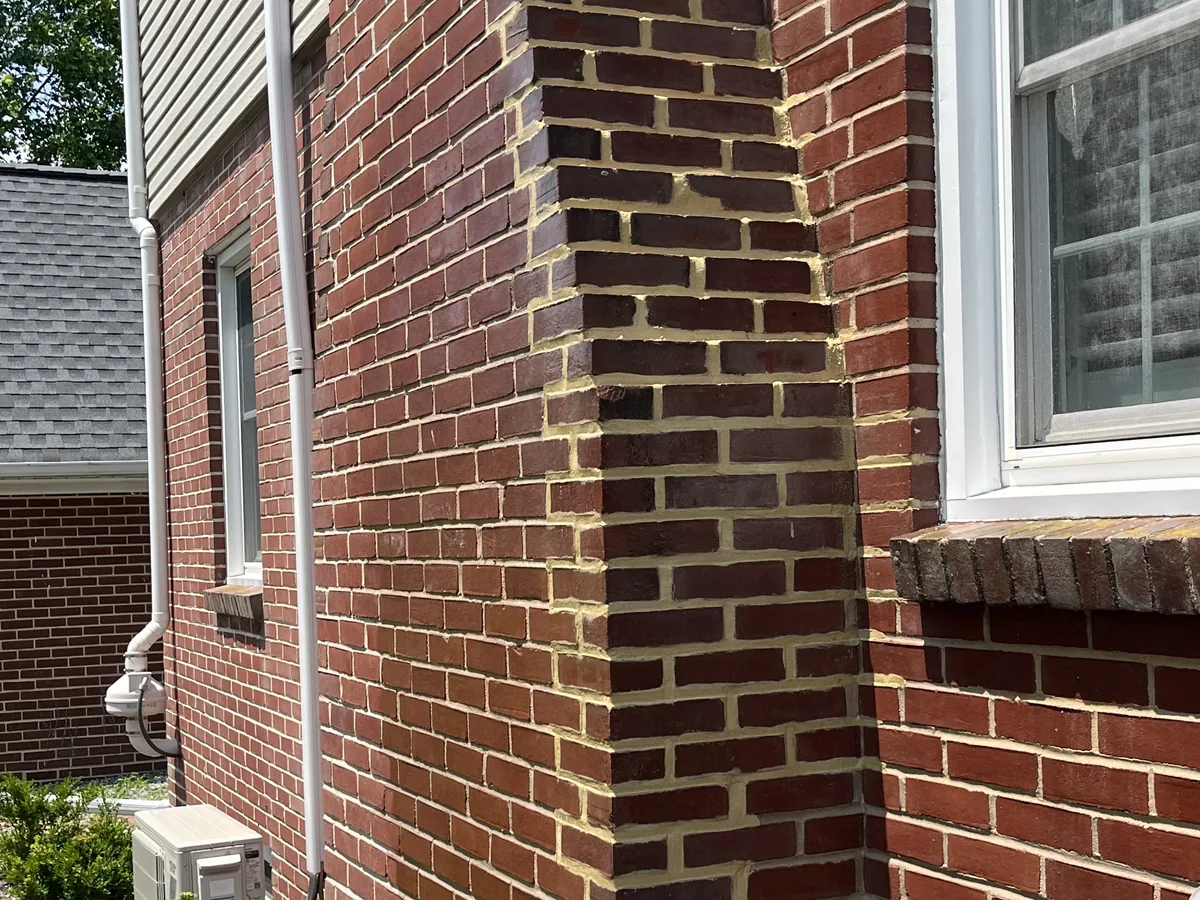 A brick chimney chase on a brick house with fresh mortar joints, brick masonry
