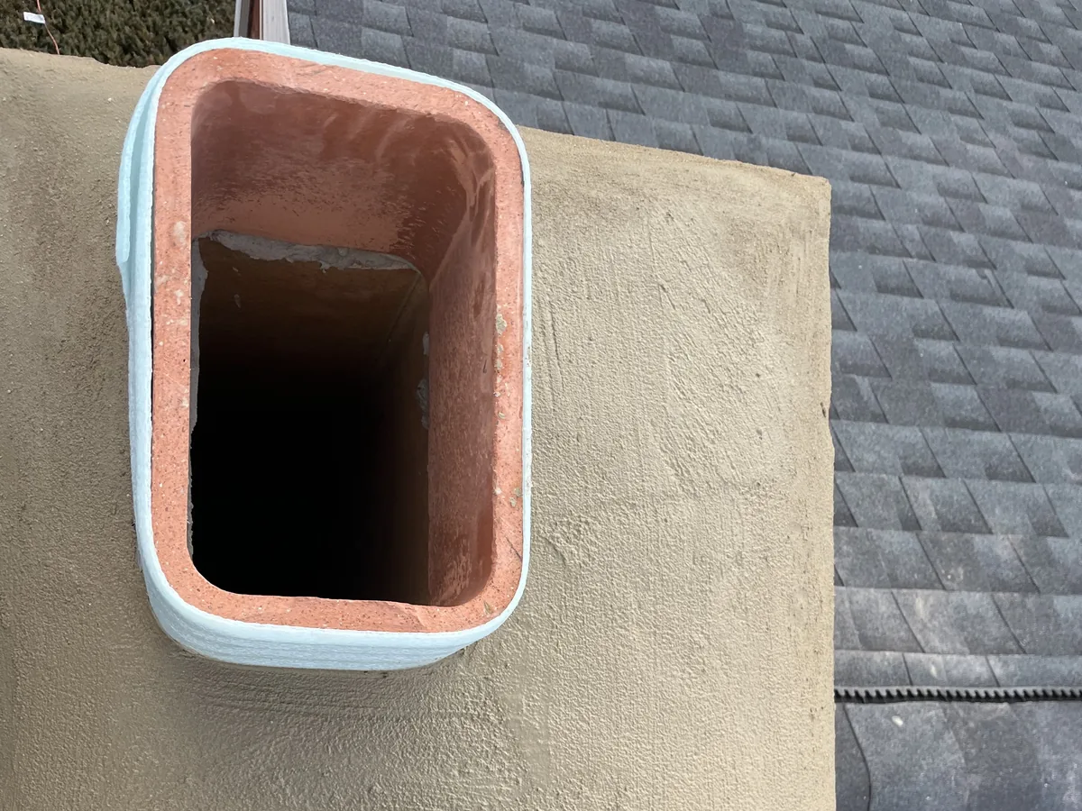 A new troweled chimney crown around two clay flue tiles, concrete work
