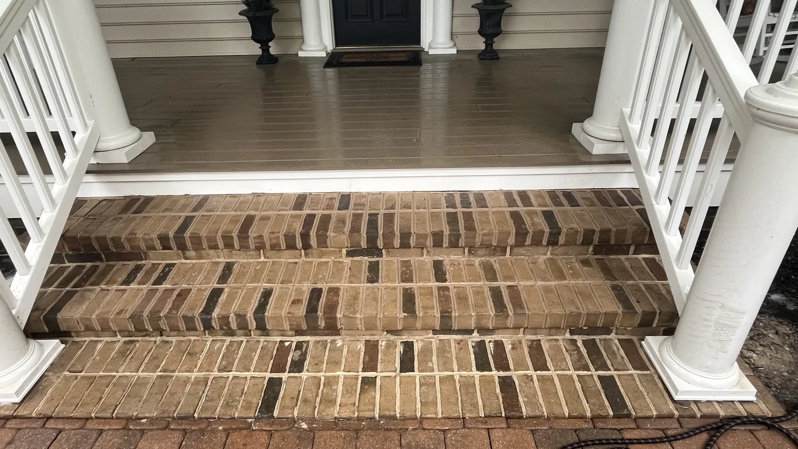 New brick porch steps below a covered front porch, masonry contractor work