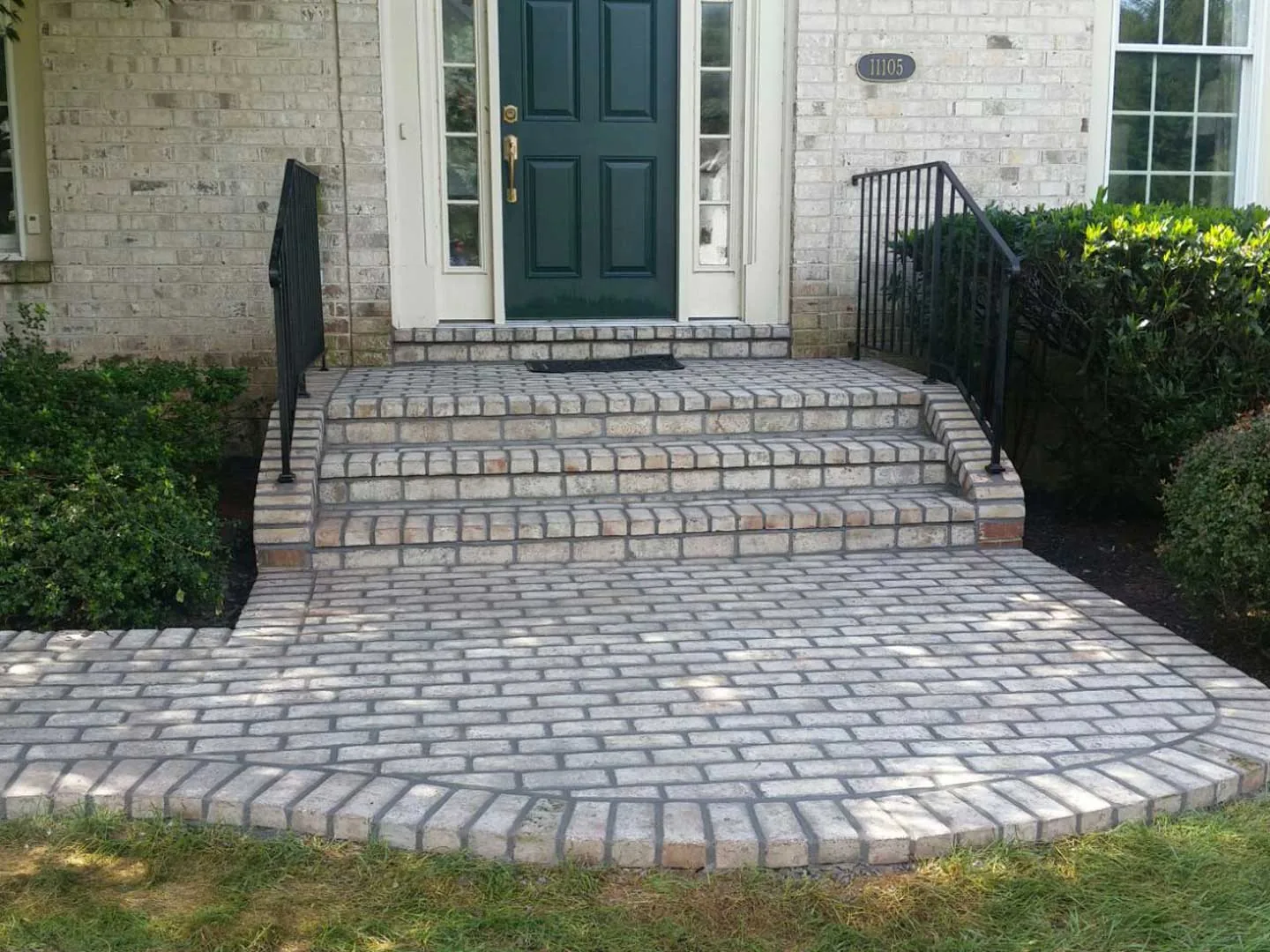 Brick front steps with iron railings and a curved brick paver landing and walk, walkways and steps